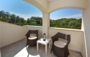 balkon z 2 krzesłami, stołem i oknem w obiekcie Three-Bedroom Holiday Home In Kmacici w mieście Kučići