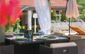 a table with plates and wine glasses on a patio at Nice Home In Unesic With Wifi in Unešić