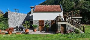 une petite maison avec un mur en pierre et un toit dans l'établissement Mountain View Cottage, à Seixal