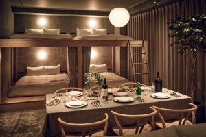 東京にあるHotel Ten Tamachiのテーブルと二段ベッドのあるダイニングルーム