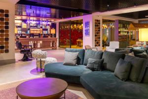 a living room with a blue couch and a bar at The NINE Lifestyle Experience in La Marsa