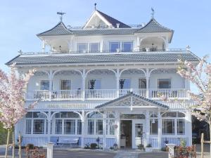 a large white house with a white porch at Haus Midsommer in Timmendorfer Strand