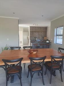 ランゲバーンにあるSerene pool house luxury 8 slp self-catering accom, Langebaan Golf estateの木製のテーブルと椅子のあるダイニングルーム