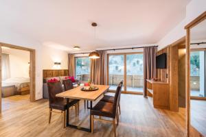 un comedor con mesa y sillas y un dormitorio en stoanmandl Wohlfühlappartements en Neustift im Stubaital