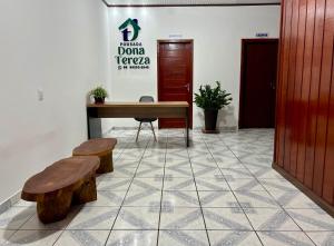 a room with a table and benches and a door at Pousada Dona Tereza in Mâncio Lima