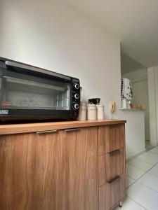 a microwave oven sitting on top of a wooden cabinet at Ap da Thay - Os Três Pandeiros in Campina Grande +7 photos