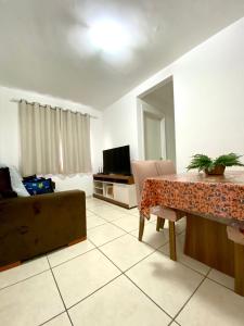 a living room with a table and a couch at Ap da Thay - Os Três Pandeiros in Campina Grande