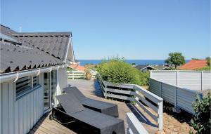 un patio con bancos y un edificio con el océano en el fondo en Holiday Home Hvedemarken Xii, en Hejls