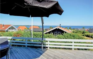 Una sombrilla negra colocada en una terraza junto a una valla. en Holiday Home Hvedemarken Xii, en Hejls