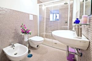 bagno bianco con lavandino e servizi igienici di Palazzo Coccoli a Santa Maria di Castellabate