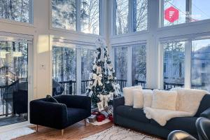 un salon avec un sapin de Noël et deux canapés dans l'établissement Casa Ibéricos in Portneuf / SPA Pool Sauna Trails, à Pont-Rouge