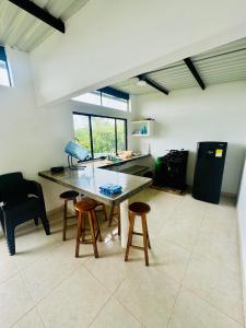 a kitchen with a table and stools in a room at Piedras del Sol Casa Campestre in Guaduas