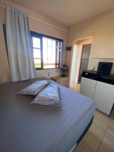 a bed with two pillows on it in a room at Apartamento em Torres RS in Torres
