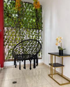 a black chair in front of a window with a table at Apartament para pareja muy acogedor y privado in Cafemba