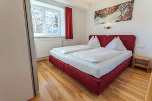 un letto in una camera con un divano rosso di Apartment Eisl a Ramsau am Dachstein