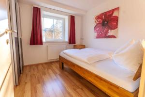 una camera da letto con un letto e una finestra con tende rosse di Apartment Eisl a Ramsau am Dachstein