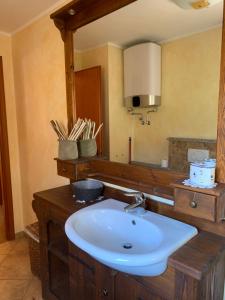 une salle de bain avec un lavabo et un miroir dans l'établissement Monica's apartment Viola, à Sauze dʼOulx 8 autres photos