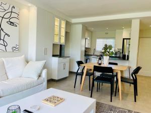 Una sala de estar con un sofá blanco y una mesa. en Tranquility Place - Goose Valley, en Plettenberg Bay