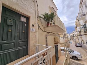 a green door on a building with a balcony at Spago rooms in Vieste