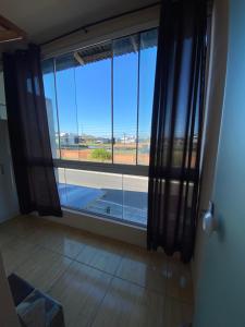 a room with a large window with a view at Apartamento em Torres RS in Torres