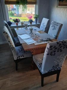 a dining room table with chairs and a wooden table with at Villa Svalan in Hällefors +9 photos