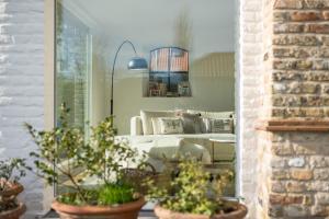 a living room with a couch and potted plants at Endless summer Knokke - Pool Villa in Knokke-Heist