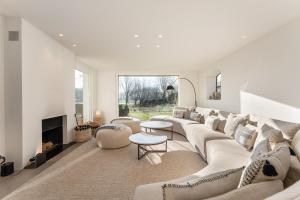 a living room with a large couch and a fireplace at Endless summer Knokke - Pool Villa in Knokke-Heist