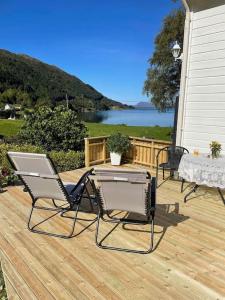 Un patio con dos sillas y una mesa en una terraza. en Oceanview House Ideal for Peaceful Holidays, en Venøya