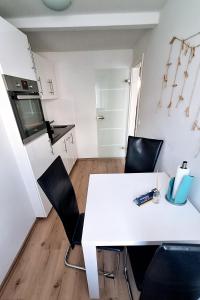 アンベルク・ブッフホルツにあるFerienwohnung in der Altstadt,4 Zentrumのキッチン(白いテーブル、黒い椅子付)