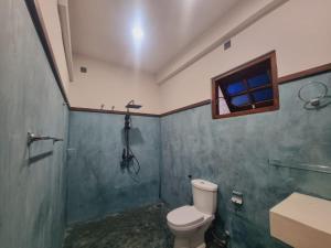 a bathroom with a toilet and a shower and a window at Pearl Surf Resort in Ahangama +27 photos