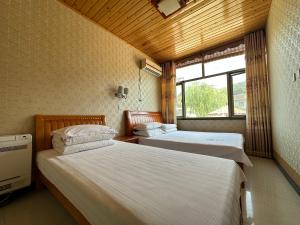 Rúm í herbergi á Huifangge Folk Inn