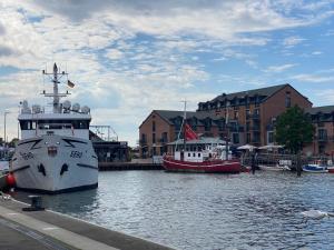 two boats are docked in the water in a harbor at Panoramablick Ostsee, Binnensee & Salzwiesen - Balkon - Stilvoll - Highspeed Glasfaser WLAN - Parkplatz - Ferienwohnung 'Freiheit' in Heiligenhafen