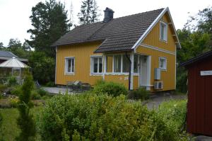 Boda GlasbrukHumlebo的黑色屋顶的黄色房子