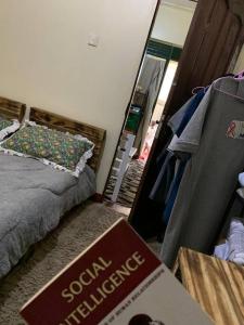 a bedroom with a bed and a book on the floor at Charming Double House in Jinja in Jinja +14 photos