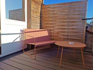 a bench and a table on a balcony at Urban Style, Hôtel Le Cheval Noir, Saint-Étienne in Saint-Étienne