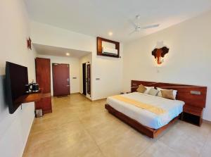 a large bedroom with a bed and a television at Spice Forest Plantation Homestay, Thekkady in Vandiperiyār