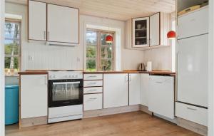a white kitchen with white cabinets and an oven at Nice Home In Knebel With Kitchen in Knebel