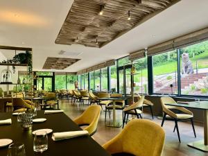 保拉扎克Richard Lequet Domaine gastronomique du Val d Atur的有桌椅和窗户的餐厅