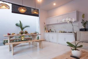 a kitchen with white cabinets and a bench in a room at Maisaba Seminyak Loft & Villas in Seminyak