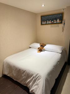 a teddy bear sitting on top of a bed at 成功溫泉民宿 in Yü-shih-ts'un +2 photos