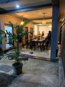 a dining room with a table and chairs and people at Pearl Surf Resort in Ahangama
