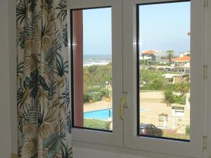 a room with a window with a view of a pool at Appartement 4 personnes entre mer et Golf à Anglet in Anglet