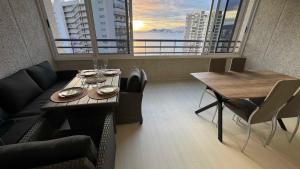 una stanza con un tavolo, un divano e una finestra di Luxury apartments TropicMar 77 a Benidorm