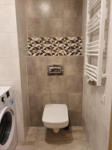 ein Badezimmer mit Toilette und Waschmaschine in der Unterkunft Apartament Sea & Sun Letnica in Danzig + 17 Fotos