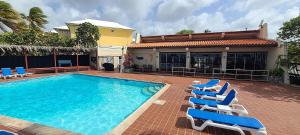 a swimming pool with lounge chairs next to a house at Sea Turtle Condo with Loaded Amenities in Christiansted