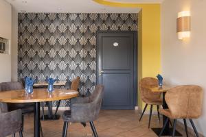 un comedor con mesas y sillas y una puerta en Auberge de la Loire, en Montjean-sur-Loire 23 fotos más