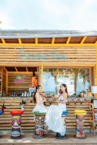 沙美岛Diamond Beach Resort的两名妇女站在一家餐馆前