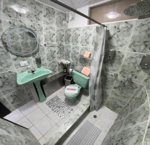 Un baño con un inodoro verde y un lavabo. en Gold House Oro, en Quito