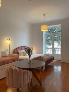 a living room with a bed and a table and chairs at Casa D'Almeida by Porto Stories in Porto