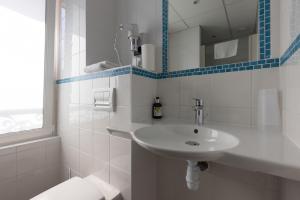 Un baño blanco con lavabo e inodoro. en Auberge de la Loire, en Montjean-sur-Loire
